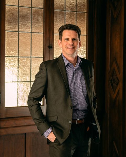 Geordie MacPherson, Consultant at Wakiya Solutions, standing in a wood-panelled room with leaded glass windows